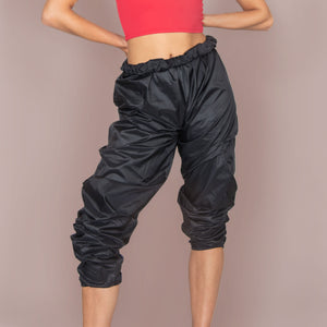 Adult model posing in black warm up pants